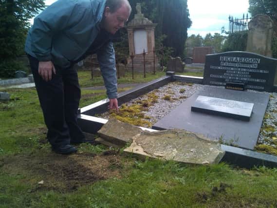 Jim Conway at one of the graves vandalised in Shankill Graveyard