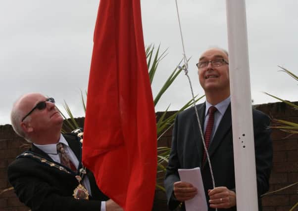 Captain Trevor Wright, Harbour Master, Port of Larne and Councillor Billy Ashe, Mayor of Mid and East Antrim Borough, hoist the Red Ensign. (Submitted Pic.)