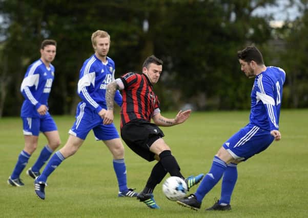 BBOB midfielder Eamon Donnelly keeps Annalong Swifts player Jonathan Gilchrist on his toes. INLS3715-119KM