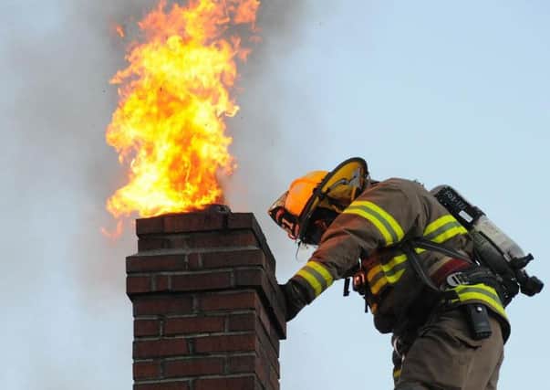 Firefighter dealing with a chimney fire. Stock image