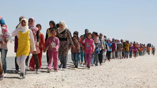 Syrian children march in the refugee camp in Jordan.