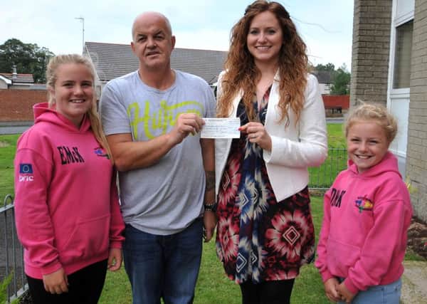 Chris Bowyer is pictured presenting a £600 cheque to Jacqueline Graham of the Child Brain Injury Trust, proceeds from a recent sponsored walk by teh Ballykeel Hip Hoppers and donations from the Ballykeel 1 residents. Included are Ballykeel Hip Hoppers Ellie McKillen and Darcey McKillen. INBT39-211AC