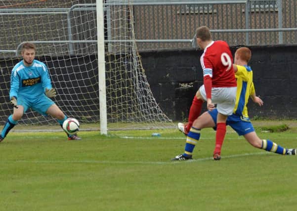 Larne skipper Paul Maguire puts the ball past the Bangor keeper to put his side one up. INLT 38-012-PSB