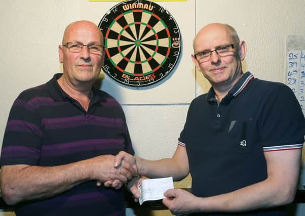 Ballymena, Harryville & District Darts League chairman John Stewart (left) presents a cheque for £150 to Graham Mills of the George Sloan Centre at Friday night's Charity finals night in the Coach. INBT 39-180CS
