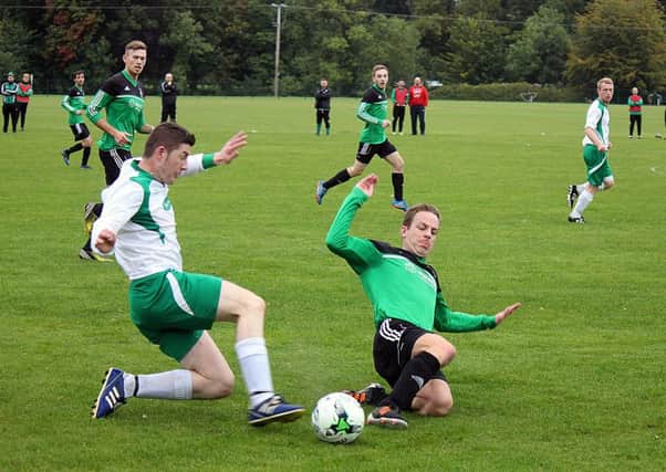 A sliding tackle for the ball during the All Saints Old Boys v FC Moylena match at the Antrim Forum. INBT 40-949H