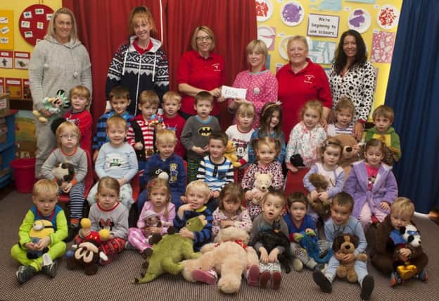 ONESIE CHEQUE. Elaine King, Leader at See-Saw Playgroup, Mosside hands over the sum of £656 to Cynthia Elder and Bernie Elder from The Gillian Adams Angel Foundation. The money was raised through a PJ/Onesie Day on Friday and included are Group Assistant.INBM40-15 051SC.