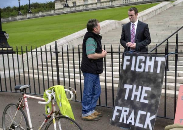 An anti-fracking protester chats with  Environment Minister Mark H Durkan at Stormont