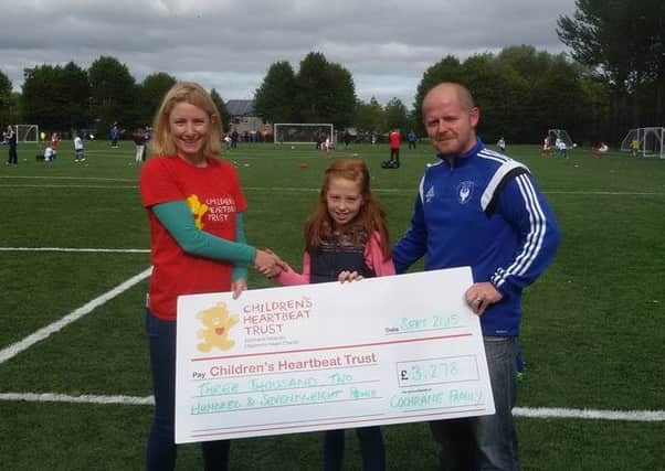 Pictured presenting £3,278 to Sarah Quinlan from the Childrens Heartbeat Trust are Barrie Cochrane along with daughter Ellie. The family held a charity football match in memory of  three of their children Aimee, Louis and Ruby who all sadly passed away from a rare, genetic heart condition.