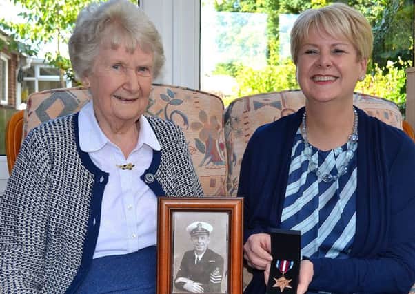 Lisburn woman Marion Hiddleston (left) and her daughter Aileen McGarrigle with a photograph of Sam Leslie during his naval service and his posthumously awarded Arctic Star medal.