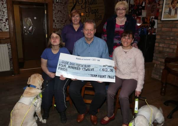 Stephen Reynolds of the Front Page Bar presents a cheque for £412 (proceeds of a table quiz held in the bar) to Torie Tennent (left) with her dog Ushi and Anne McKeown, with her dog Flossy, who accept it on behalf of Guide Dogs for the Blind. Included is Front Page staff member Maggie Magee and Barbara White of Guide Dogs for the Blind. INBT 42-103JC