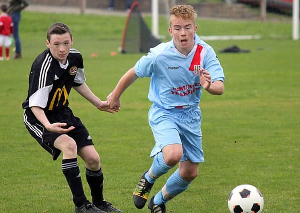 A Ballymena United under-16 player bursts away from his Carniny marker. INBT 41-933H
