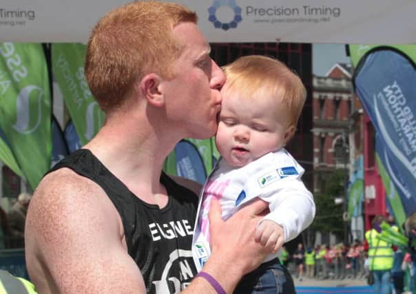 Eugene Ferry carries baby daughter Dakota across the finish line during last year's Walled City Marathon. Picture Margaret McLaughlin
