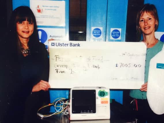 Alison Harrison-Mitchell (left) presents a £7,005 cheque to a Sally Hamilton of the Perinatal Trust.