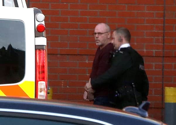 Alex McCrory (left) is taken into custody at Belfast magistrates court. Picture date: Tuesday December 17, 2013.
