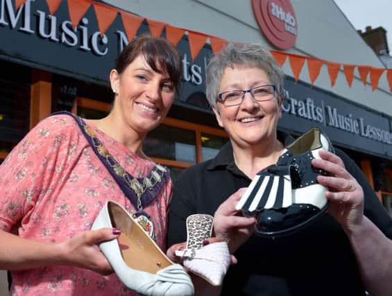 Mid Ulster Council chair Linda Dillon and Carol Doey with some of the celebrity shoes at the Charity Walk.INMM4215-380