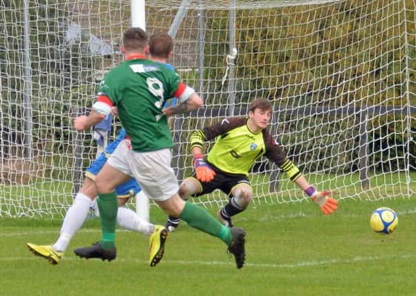 Number nine, Reece McGinley strokes the ball past the Lisburn Rangers keeper to put Larne Tech OB one up. INLT 41-020-PSB Photo: Phillip Byrne
