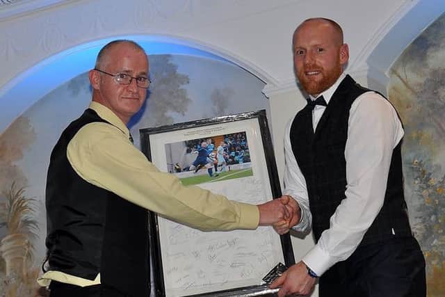 Photographer Damian McKee, of Picture Magic Studios, presents Dwayne Nelson with a framed, signed photo montage from his testimonial game against Rangers. Picture: Brenda Carolan.