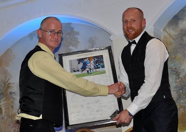 Photographer Damian McKee, of Picture Magic Studios, presents Dwayne Nelson with a framed, signed photo montage from his testimonial game against Rangers. Picture: Brenda Carolan.