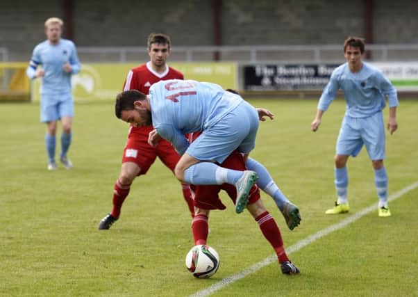 Institute's Garbhan Friel tangles with a Ballyclare Comrades defender on Saturday. INLS4115-113KM