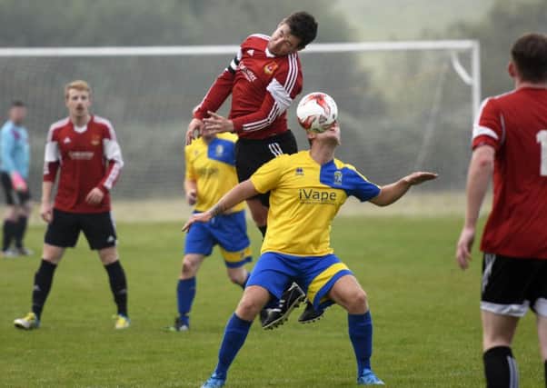 Foyle Wanderers skipper David Scanlon wins this midfield tussle with Roe Valley player Loughlain Toland. INLS4215-141KM