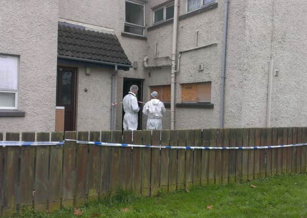 Forensic team enter the front door of the flat where the late Marcell 'Junior' Seeley was found dead yesterday