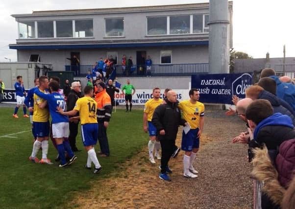 This image, taken from social media, shows Allan Jenkins being restrained by team-mates and opponents from a confrontation with Ballymena United supporters after Saturday's defeat at Glenavon as United skipper Jim Ervin attempts to defuse the situation.