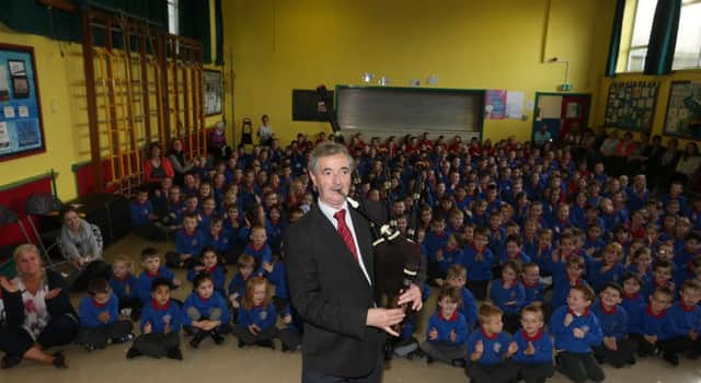Ballymena Primary School principal Mr Brownlow, who is an accomplished piper, plays the pipes for the pupils and staff at his retirement assembly last week. INBT 43-103JC