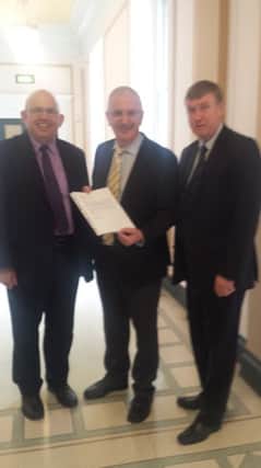 John Finlay presents the petition to the Minister for Regional Development, Mr Danny Kenendy MLA, in 2015,