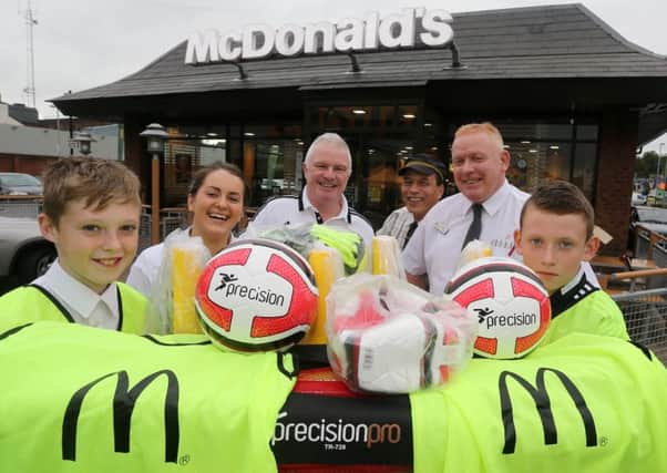 McDonald's manager Kade O'Reilly hands over football equipment to Carniny Youth's Billy O'Flaherty and players Ryan Clarke and Leon Graham while looking on are assistant manager Gemma Caldoerwood and staff member Gary Delantar. INBT 42-170CS