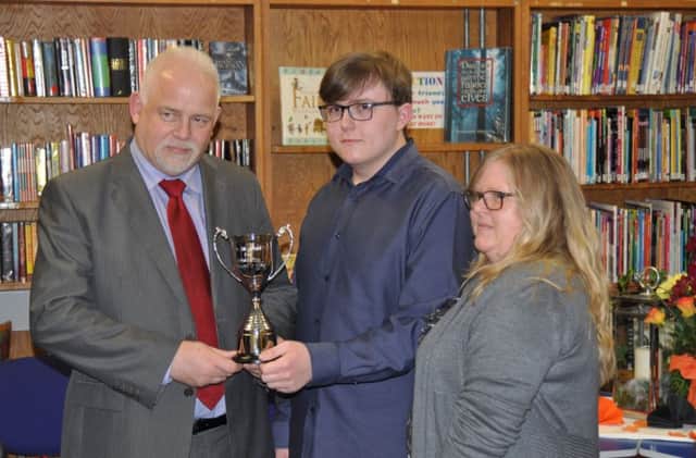 Mr D Martin (Randox Laboratories) presents the Dr Fitzgerald Cup for Outstanding Attainment in Science to Kyle McClean, pictured here with his mother.