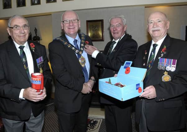 Edwin Rankin, Poppy Appeals Organiser from Carrickfergus RBL pins a Poppy on Alderman, Billy Ashe, Mayor of Mid and East Antrim Borough Council to launch this year's appeal, also pictured are RBL Members, Billy Crozier and James McReavie. INCT 44-210-AM