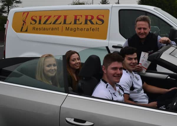 Paul Clarke from Sizzlers Restaurant shows Rainey pupils Andrew Brown, Anton Lupari, Rachel Hardy and Kate Mc Gowan his menu for the upcoming Drive In Move.