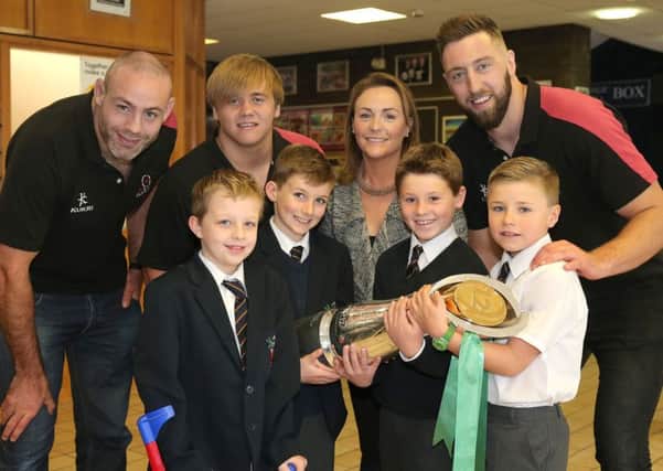 Lisburn store director Natalie Latham (back, 2nd right) with Ulster Rugby players, from left Lewis Stevenson, Kyle McCall and Peter Browne. Front row are Wallace pupils (l-r) Finlay Slattery (P5) Brady Chambers (P6) Matthew Dickson (P6) and Owain Williams (P5).