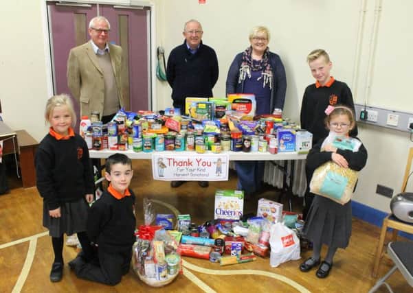 Pictured at Linn Primary School's Harvest Assembly is guest speaker Ruth Turner from the Church of the Nazarene at Millbrook. The children made very generous donations to Alex and Alan from Larne Food Bank.  Pictured are pupils  Alex (standing at the back), Evie (holding the pasta), Jessica (standing on the left) and Jaylin (kneeling). INLT-44-711-con