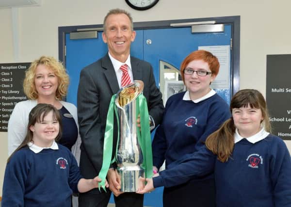 Principal of Roddensvale School, Mr John Madden shows off the Guinness PRO 12 rugby trophy to pupils, Courtney, Heather and Amy. The trophy was brought to the school by Dierdre McAree, store director of Specsavers in Larne. INLT 42-011-PSB