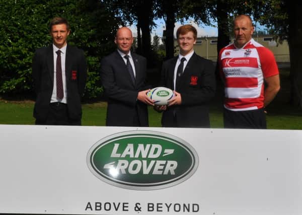 Mr Stephen Surgenor, of Land Rover, presents sponsorship of Ballymena Academy First XV to players Joel Gocher and Mark Thompson. Looking on is head coach John Andrews.