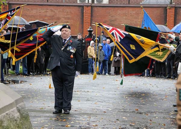 Ballymena RBL member Davy Davison pays his respects with lowered flags. INBT 46-916H