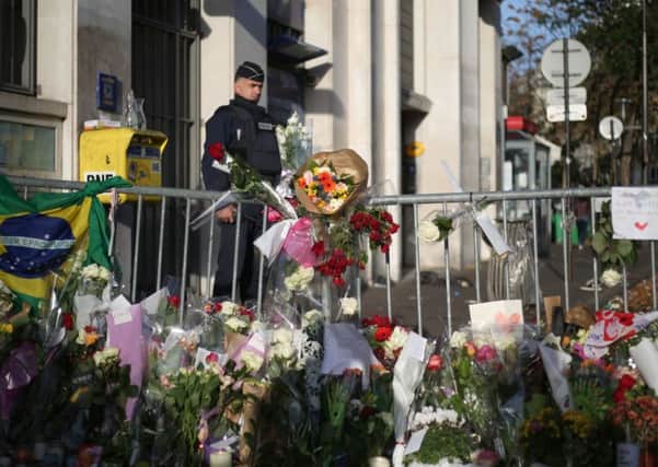 Flowers and tributes are left close to the Bataclan concert hall, Paris, one of the venues for the attacks in the French capital.