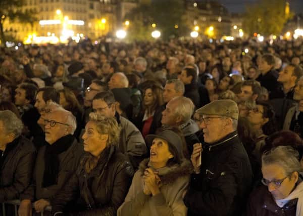 People gather outside for a national service for the victims of the terror attack at Notre Dame cathedral in Paris, Sunday, Nov. 15, 2015.
