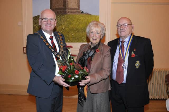 The Lord Lieutenant for County Antrim Joan Christie OBE is presented with a bouquet of flowers by the Mayor of Mid and East Antrim Council, Councillor Billy Ashe and George Horner, president of Carrickfergus Royal British Legion. INCt 46-202-AM