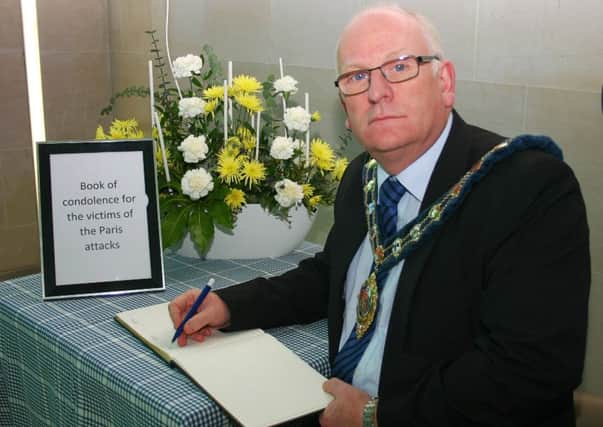 Mayor of Mid and East Antrim Billy Ashe signs the book of condolence for the victims of the Paris attack. INLT-47-703-con