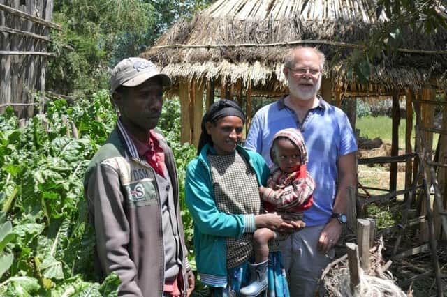 Dr Lindsay Easson visiting the Teshale family with their healthy crop of spinach in the background.  They live near the Dendii crater lake in Central Ethiopia.