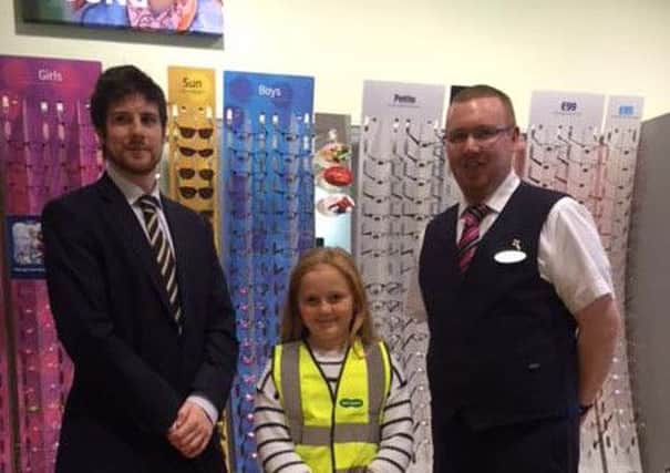 Lauren Ball 'modelling' the high vis vest with Specsavers team members Sheldon Herald and Alex Tait.
