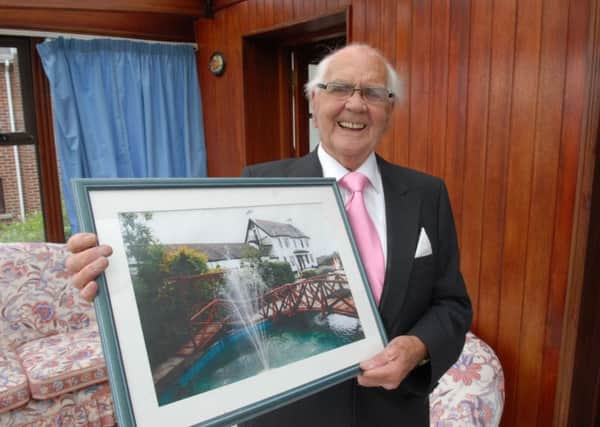 Crawford Magill with a photograph of the Highways as it looked under his ownership. INLT 36-410-PR