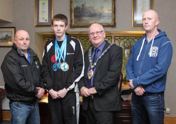 Jordan Reid who won a double world title at this year's World Kickboxing Association Unified World Championships, included are instructor Robert Cassells, the Mayor of Mid and East Antrim Council, Cllr Billy Ashe and Jordan's dad Colin Simms INNT 49-516-SO