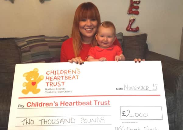 Little Molly McKnight and her mum Jodie McCullough with their £2,000 cheque for Childrens Heartbeat Trust. INNT 50-507CON