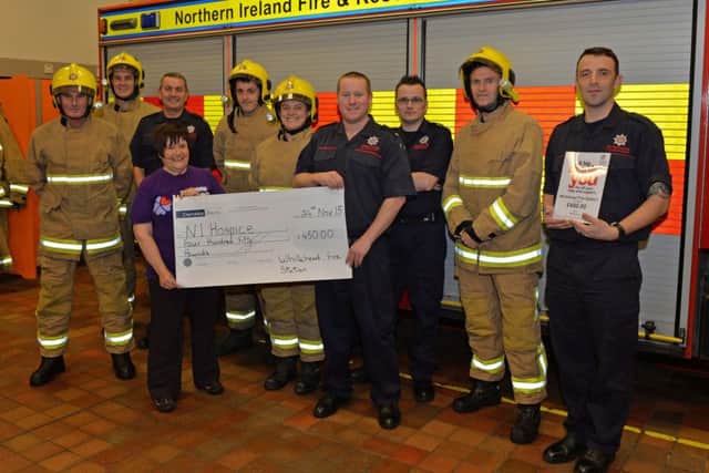 Members of the Northern Ireland Fire and Rescue Sevice from Whitehead Fire Station present Lynda Marshall MBE from the NI Hospice with a cheque. INCT 48-003-PSB