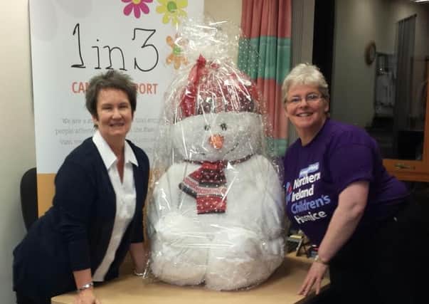 Karen McMeekan from the 1in3 Cancer Support Group is pictured donating a cuddly snowman to Catherine O'Hara, community fundraiser with the NI Children's Hospice.  
  INCT 50-725-CON