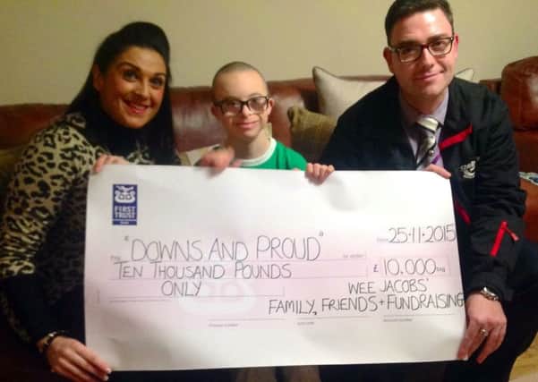 Carolyn Herdman and her partner Michael Kirk presenting Jay Beatty from Downs and Proud with a £10k cheque