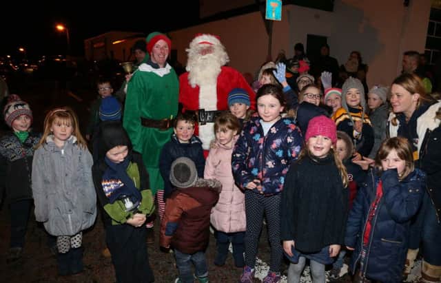 Santa Claus pictured at the switching on of the Glenariff Christmas lights on Sunday evening with some of the children who came to see him. inbm51-15 PHOTO BY KEVIN MCAULEY